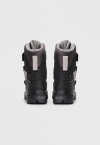Czarne i szare wodoodporne buty z teksturowanego materiału, wyściełanym kołnierzem, regulowanymi paskami i solidną gumową podeszwą zapewniającą przyczepność.