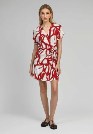 Robe enveloppante rouge et blanche présentant des motifs abstraits, des manches courtes et un lien sur le côté. Tissu doux avec une texture légère.