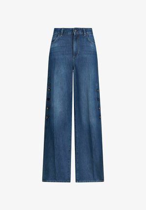 Magasított derékú, széles szárú kék farmernadrág oldalsó gombos díszítéssel és első zsebekkel, gombos és cipzáras záródással.