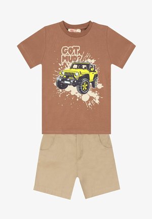 Brązowy bawełniany T-shirt z grafiką żółtego pojazdu terenowego i napisem "GOT MUD?", połączony z beżowymi bawełnianymi szortami z przednimi kieszeniami.