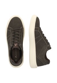 Braune Wildleder-Sneaker mit weißer Gummisohle, ausgestattet mit Kontrastnähten, flachen Schnürsenkeln und einem runden Zehendesign. Auffälliges Markenlogo sichtbar.