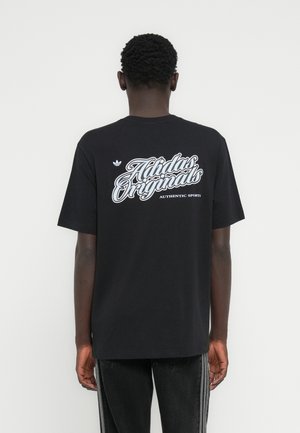 Μαύρο βαμβακερό μπλουζάκι με μεγάλο λευκό λογότυπο «Adidas Originals» και κείμενο «Authentic Sports» στην πλάτη, με κοντά μανίκια και στρογγυλή λαιμόκοψη.