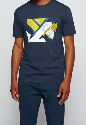 Dunkelblaues Baumwoll-T-Shirt mit grafischem geometrischem Design in Gelb, Blau und Weiß, versehen mit einem Hauch von Textur und dem Markennamen "BOSS".