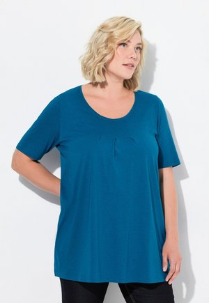 Türkisfarbener T-Shirt mit kurzen Ärmeln aus weichem Stoff, ausgestattet mit einem runden Ausschnitt und feinen Falten vorne. Lässiger, lockerer Schnitt.