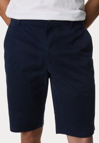 Pantaloni shorts in cotone blu navy con taglio dritto, dotati di chiusura a bottone e tasche laterali, texture liscia e cuciture a contrasto.