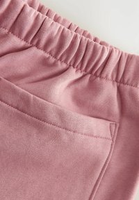 Shorts en coton rose mélangé avec une taille élastique, surface texturée et une poche latérale, avec des détails cousus et une finition lisse.