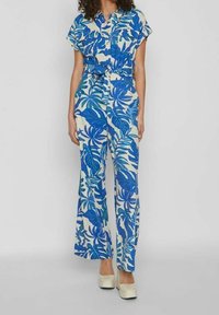 Modrý a bílý květinový overal s krátkým rukávem, páskem v oblasti pasu, širokými nohavicemi a uvolněným střihem. Vyroben z lehkého materiálu.