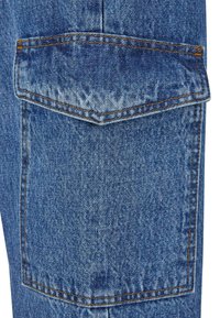 Bolsillo de jeans de mezclilla en azul, con un diseño de solapa puntiaguda, costuras en tono y un acabado texturizado con un efecto de lavado descolorido.