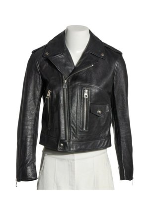 Chaqueta de cuero negra de motorista con cremalleras plateadas asimétricas, cuello con botones a presión, puños con cremallera y bolsillo con solapa en torso de maniquí blanco.