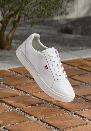 Vita syntetiska sneakers med en slät yta, rund tåsko och platt gummisula. Inkluderar subtilt logotypdetalj på sidan.