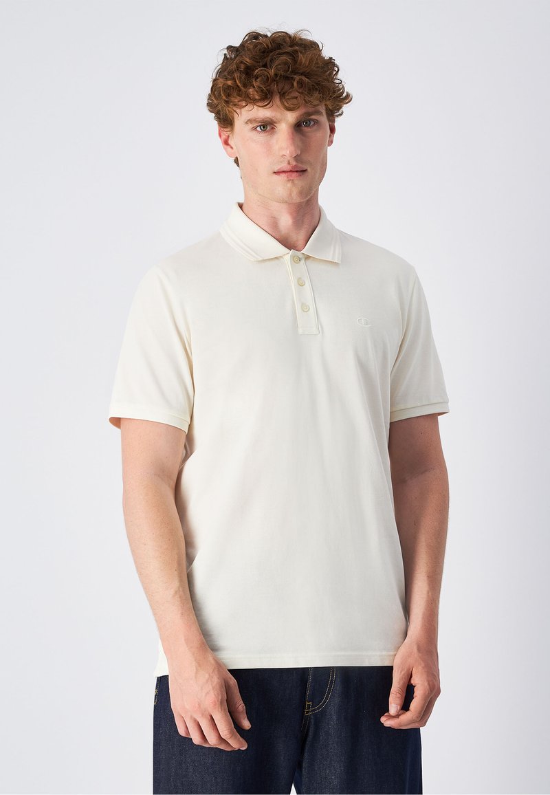 Cremfarbener Poloshirt mit klassischem Kragen, drei-Knopf-Leiste, kurzen Ärmeln und dezentem Logo-Akzent auf der Brust. Glatte Baumwolltextur.