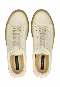 Weiße Leder Low-Top Sneakers mit beigen Gummisohlen und Schnürsenkeln, von oben betrachtet, mit "Sneaky Steve" Branding im Inneren.