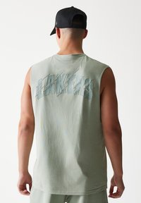 Αμάνικη, ανοιχτοπράσινη μπλούζα με τη λέξη «LAKERS» σε τρισδιάστατα γράμματα στην πλάτη. Μαλακό ύφασμα, άνετη εφαρμογή, μινιμαλιστικός σχεδιασμός.