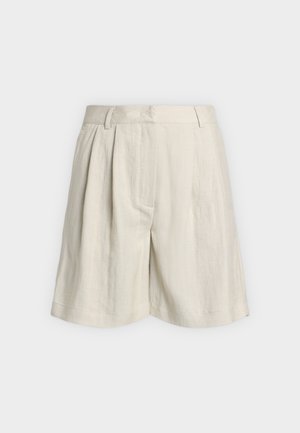 Beige højtaljede shorts med bæltestropper, forreste læg og brede ben, vist mod en enkel lys baggrund.