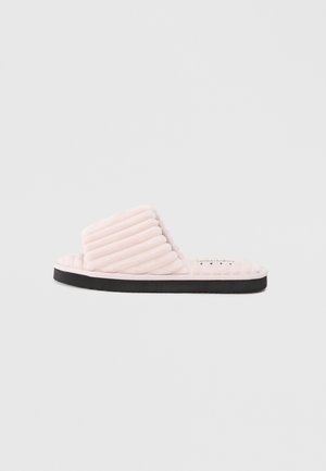 Lyserød, tætsiddende plush-sandal med en tykk ribbet overdel, sort gummisål og rund form, designet til komfort og let at have på.
