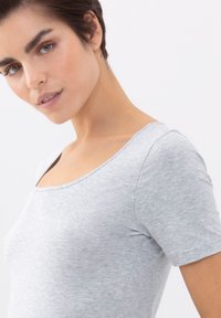 Maglietta grigia a maniche corte con scollatura arrotondata, realizzata in un tessuto morbido e elastico. Texture liscia con leggere variazioni di tonalità.