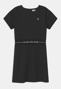 Czarna sukienka z krótkimi rękawami, okrągłym dekoltem i dopasowanym talią. Posiada pasek z logo Calvin Klein Jeans w talii. Gładka tekstura materiału.
