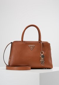 Sac à main en cuir marron avec deux poignées supérieures, une bandoulière amovible et une plaque logo en métal. Comprend un porte-clés en guise d'accent.