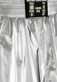 Scheda punteggio da boxe in argento con finitura lucida, realizzata in un tessuto testurizzato, che mostra dettagli di punteggio stampati in nero e verde neon e il numero del round.