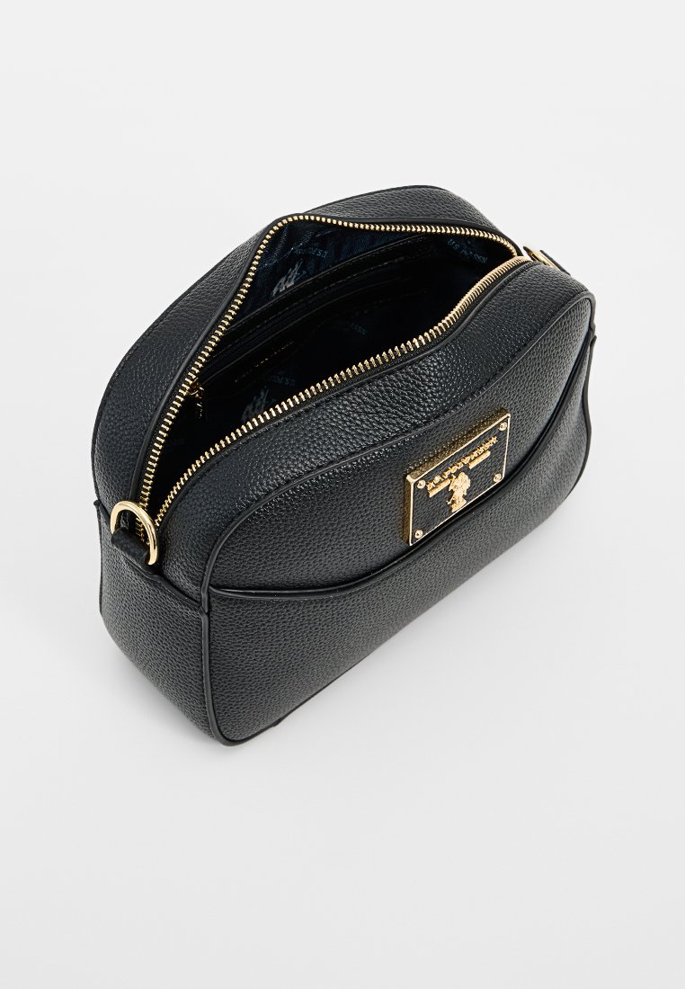 Sac en cuir noir texturé avec une forme arrondie, fermeture éclair dorée et un détail en plaque à l'avant. Le haut ouvert révèle un intérieur spacieux.