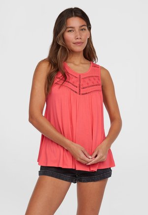 Korallefarbenes ärmelloses Top mit rundem Ausschnitt, ausgestattet mit bestickten Details und einer fließenden A-Linien-Form. Kombiniert mit schwarzen Denim-Shorts.