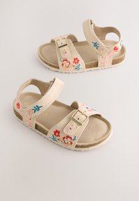 Beige sandalen met bloemrijke borduursels in roze, rood en blauw. Voorzien van verstelbare bandjes en een getextureerde zool. Details met een gespaccent.