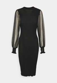 Robe noire côtelée avec des manches longues transparentes présentant une texture à pois et des poignets froncés. Encolure ronde et silhouette ajustée.