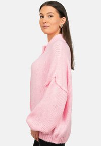 Lichtroze oversized trui met een gebreide textuur, wijde mouwen, geribbelde zoom en een ontspannen pasvorm, die een casual ontwerp laat zien.