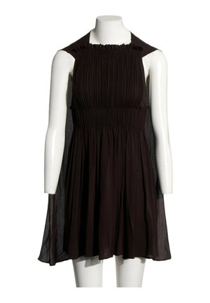 Robe noire sans manches avec corsage froncé et jupe fluide exposée sur un mannequin blanc sans tête sur fond blanc.