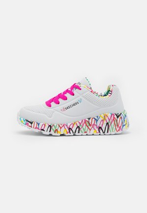 Biały sneaker Skechers z różowymi sznurowadłami, kolorową podeszwą w serduszka oraz wielokolorową wewnętrzną wyściółką, widoczne logo z boku.
