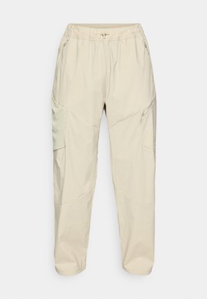 Beige lette cargobukser med elastisk talje, lynlåse i sidelommerne og et tapered ben-design for en afslappet pasform.