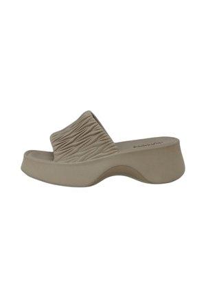Sandalo beige slip-on con ampia fascia testurizzata e spesso plateau curvo, mostrato di lato su sfondo bianco.