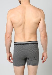 Svartvita randiga boxer briefs med en elastisk midja och en tight passform, som visar en slät tygtextur.