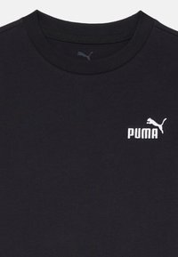Juodas medvilninis marškinėliai su apvalia iškirpte, trumpomis rankovėmis ir siuvinėtu baltu Puma logotipu ant krūtinės.