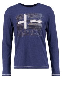Dlouhý rukáv námořnické modré tričko vyrobené z měkkého materiálu, s grafikou bílého kříže a textem pod ním, oblečeným kulatým výstřihem a kontrastním šitím.