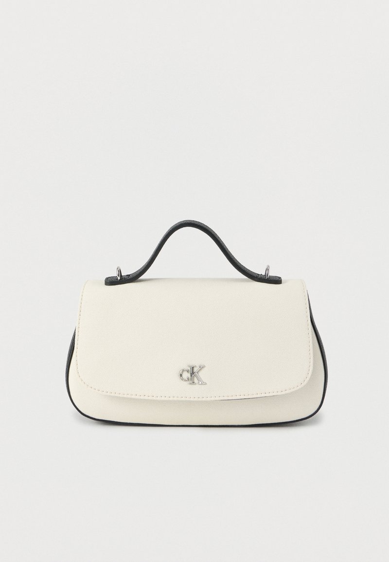 Sac à main blanc au design structuré, accents noirs et poignée supérieure. Présente un logo argenté à l'avant et une texture lisse.