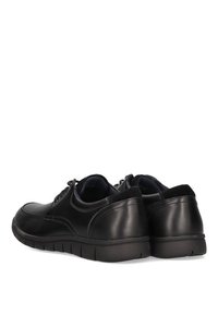 Zapatos de cuero negro con puntera redondeada, diseño de cordones y suela de goma texturizada. Acabado suave con detalles de costura mínimos.