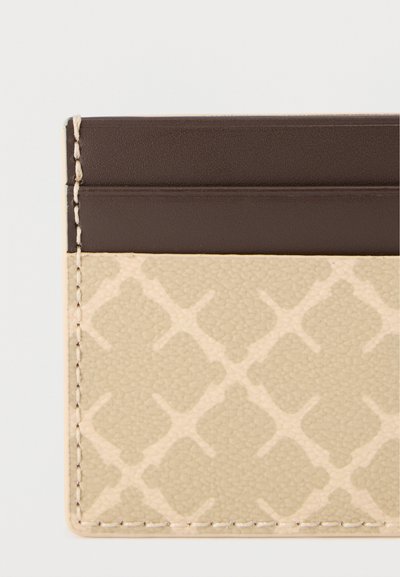 Μπεζ και καφέ θήκη καρτών με γεωμετρικό μοτίβο και εμφανείς ραφές κατά μήκος των άκρων σε απλό λευκό φόντο.