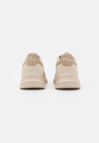 Beige sneakers with a suede and mesh upper, rounded toe, padded collar, and a textured rubber sole. Features "Mexxx" logo in white.