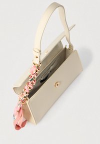 Sac à main beige en cuir lisse avec une fermeture à bouton doré, doté d'une bandoulière tressée avec des accents en tissu à motif floral.