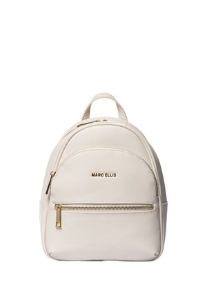 Petit sac à dos beige Marc Ellis avec des fermetures éclair dorées et un logo, comprenant une poche zippée à l'avant et une poignée de transport supérieure.