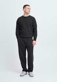 Mørkegrå sweatshirt og matchende sweatpants i blødt materiale, med rund hals, elastisk talje og snorede detaljer.