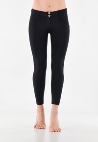 Leggings neri realizzati in tessuto elasticizzato, con chiusura a bottoni sul davanti, due tasche anteriori e una vestibilità slim che si restringe alla caviglia.