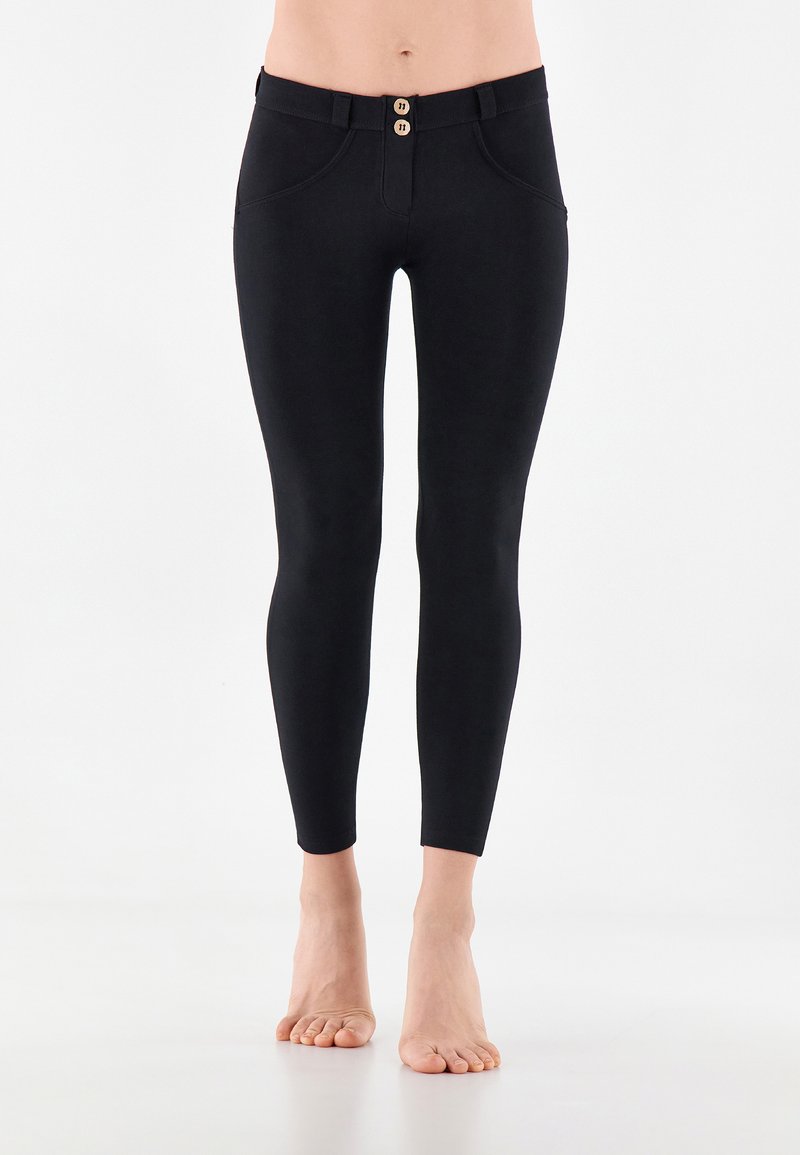 Leggings neri realizzati in tessuto elasticizzato, con chiusura a bottoni sul davanti, due tasche anteriori e una vestibilità slim che si restringe alla caviglia.