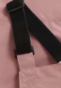 Rosa tyg med svart texturerad rem och plastdetaljer, med rena sömmar och fyrkantig form samt justerbar längd.