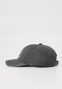 Sort denimkasket med en buet skygge, detaljeret hvidt logo foran, justerbar rem bagpå og tekstureret stoffinish.