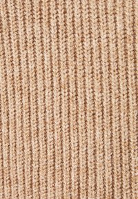 Beige pruhovaná textilie s měkkým, strukturovaným povrchem a vertikálními pruhy. Materiál vypadá jako pletený a vykazuje teplou a přívětivou barvu.