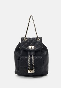 Sac à dos noir en similicuir matelassé avec bandoulière chaîne et ferrures dorées. Doté d'une poche avant et d'un rabat supérieur avec un fermoir.