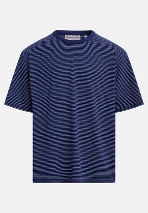 Marineblaue T-Shirt mit kurzen Ärmeln, dünnen weißen horizontalen Streifen und Rundhalsausschnitt, im Kragen mit der Aufschrift "REDEFINED REBEL" versehen.