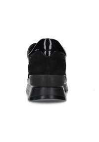 Sneaker in suede nero con tacco in pelle lucida nera, parte superiore liscia e suola in gomma testurizzata, caratterizzata da una punta arrotondata e dettagli sottili.